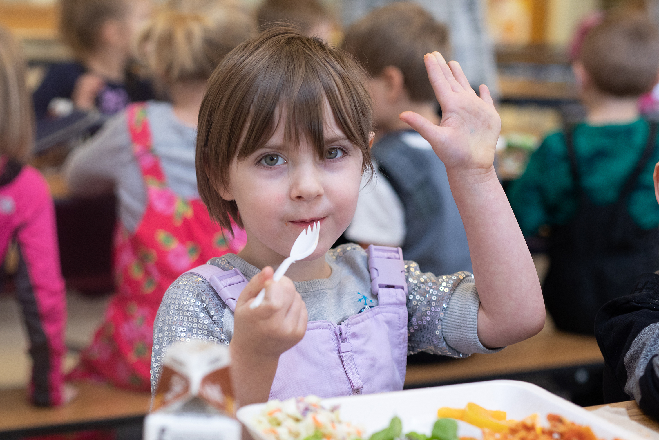 Young girl eats Michigan-grown vegetables in a school cafeteria